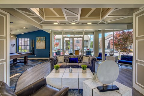 a living room with couches and a table with a mirror